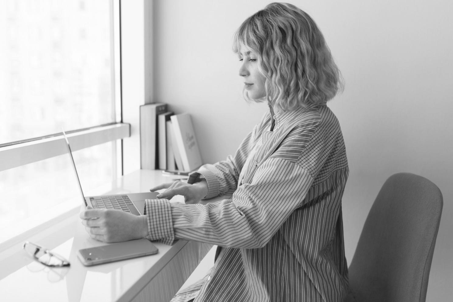 Person beim Budgetplanen mit Laptop und Notizen